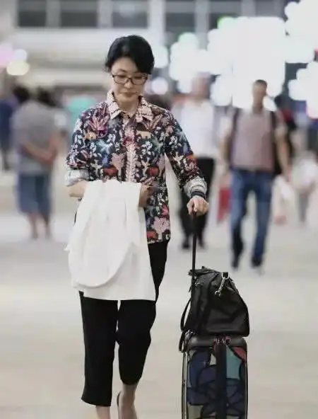  表情周涛现身机场被偷拍,碎花衬衫凸显老气,表情却成了亮点表情